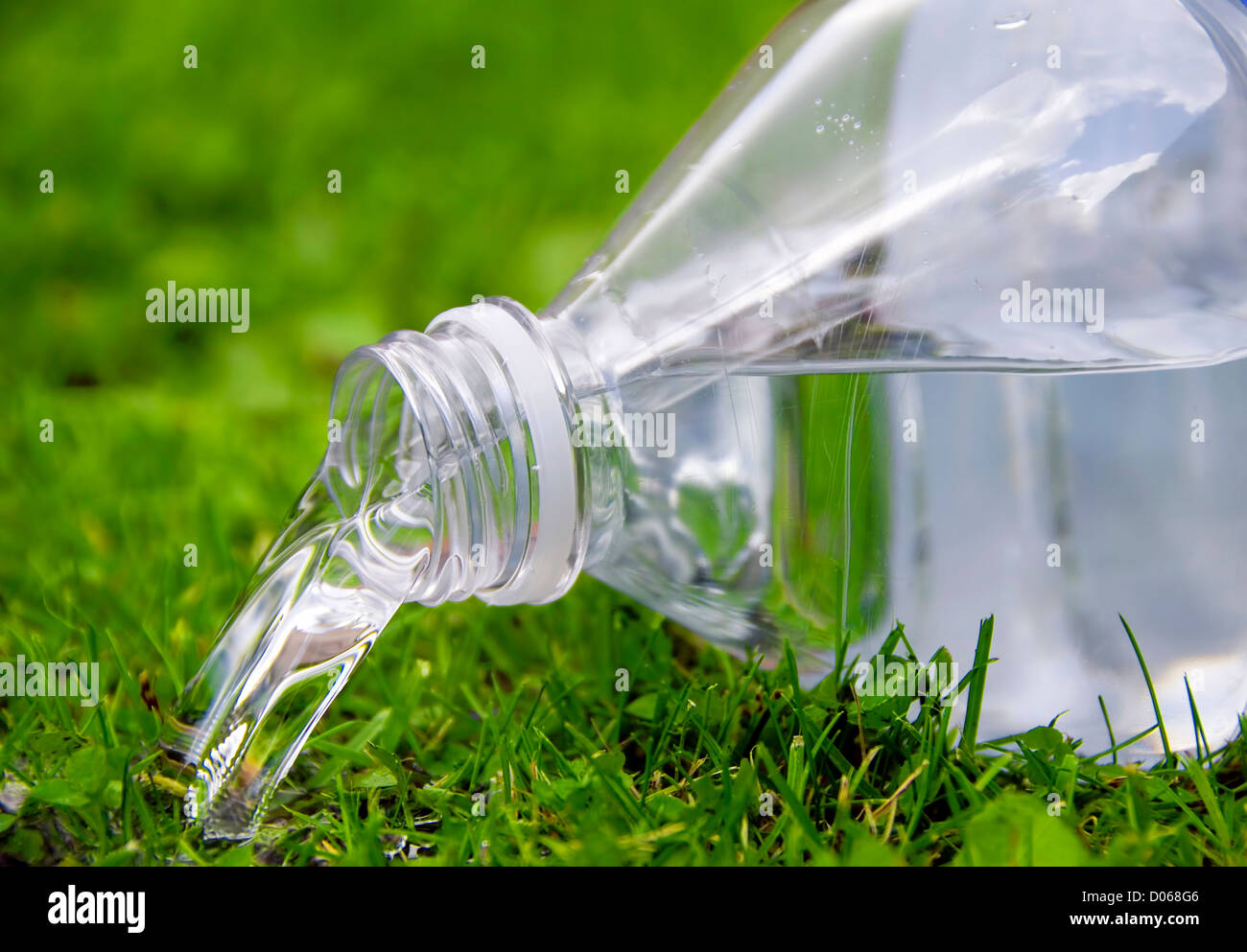 an opened bottle of water upside down in the grass Stock Photo - Alamy