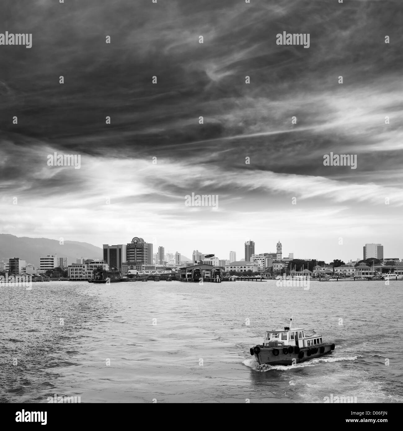 City bay with single boat and skyscrapers in Penang, Malaysia, Asia. Stock Photo