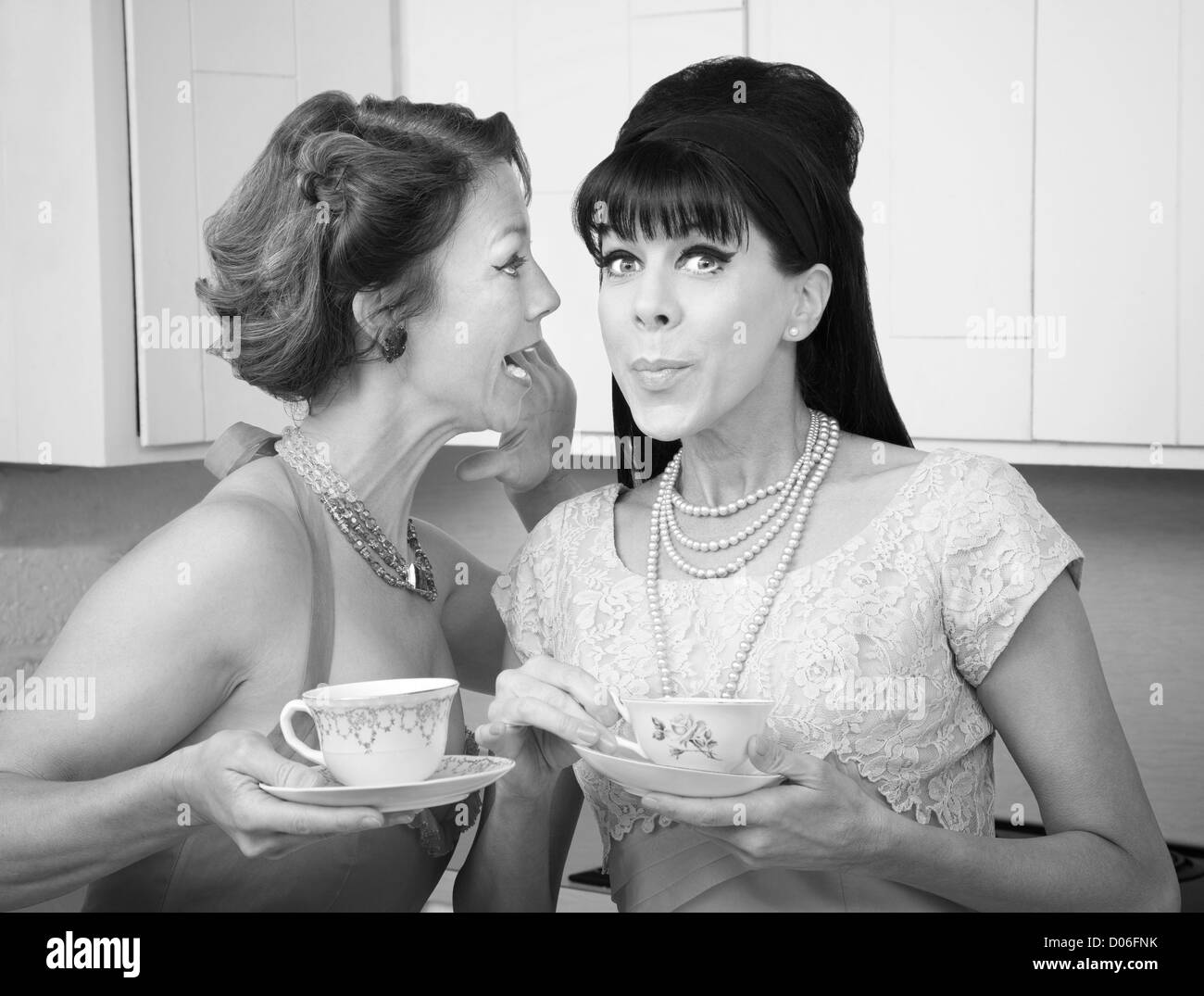 Retro styled Caucasian woman shares a secret with her friend Stock Photo