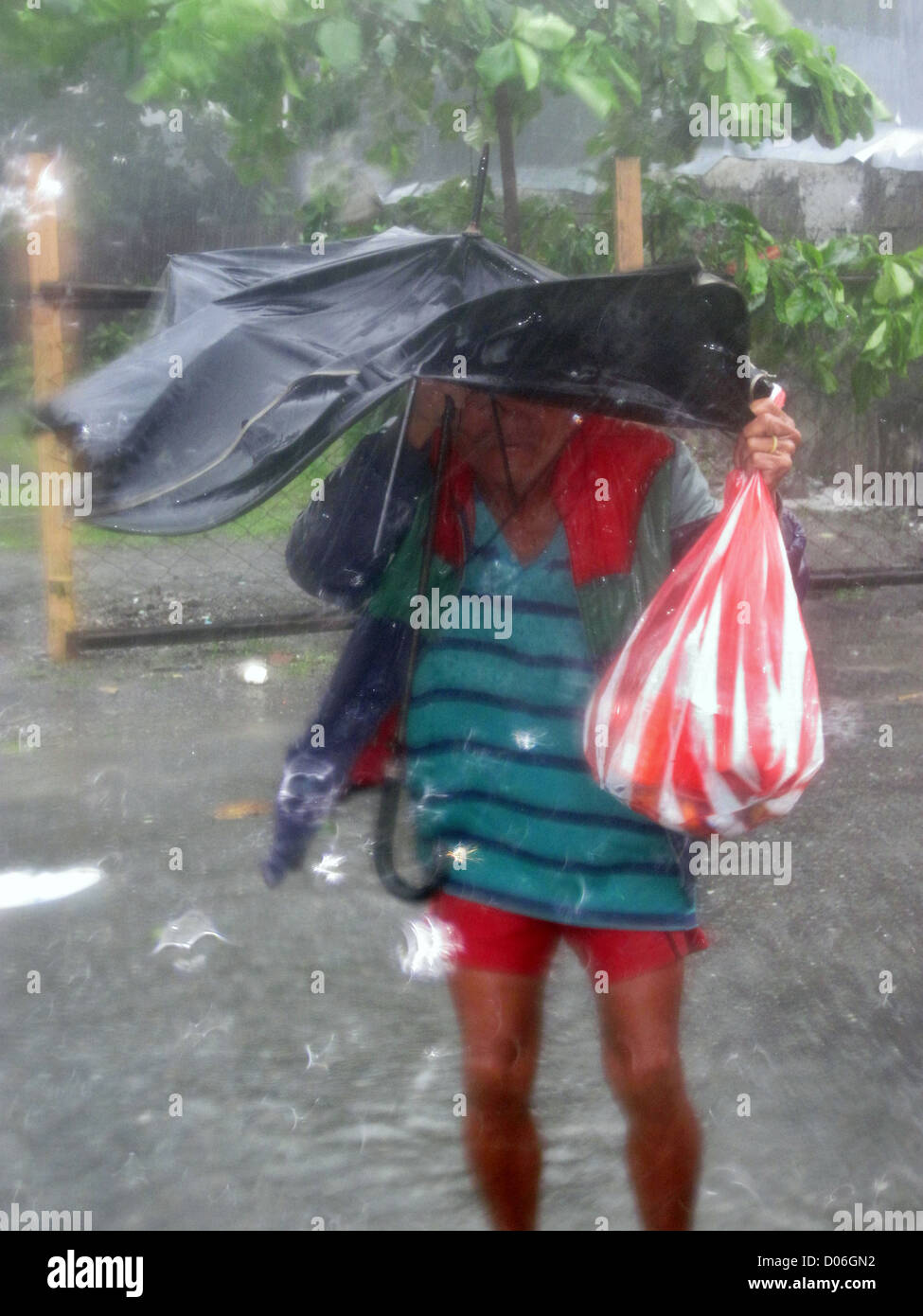 Filipino man struggles in strong typhoon wind in the Philippines. Stock Photo