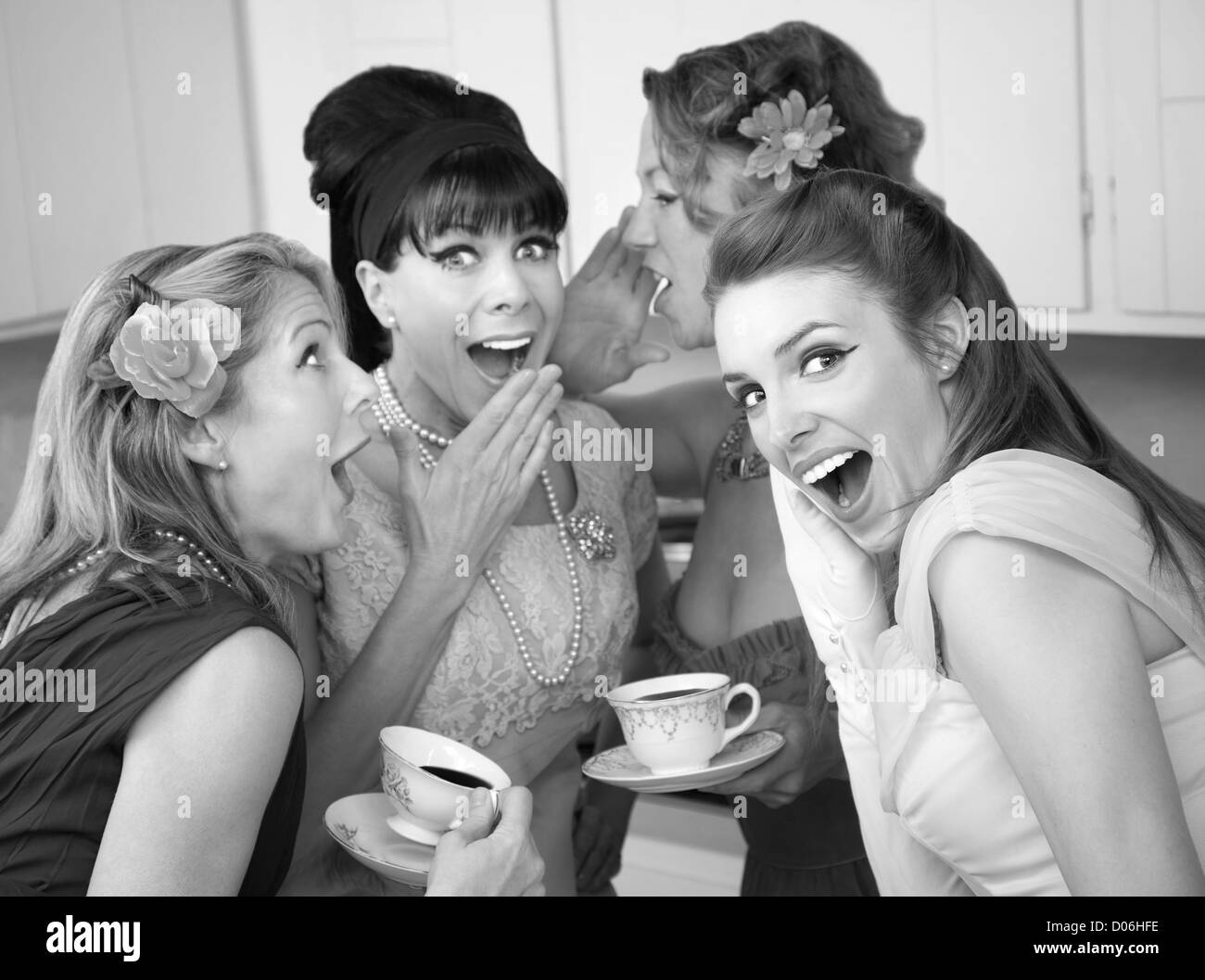 Group of four retro fashion housewives tell secrets in the kitchen Stock Photo