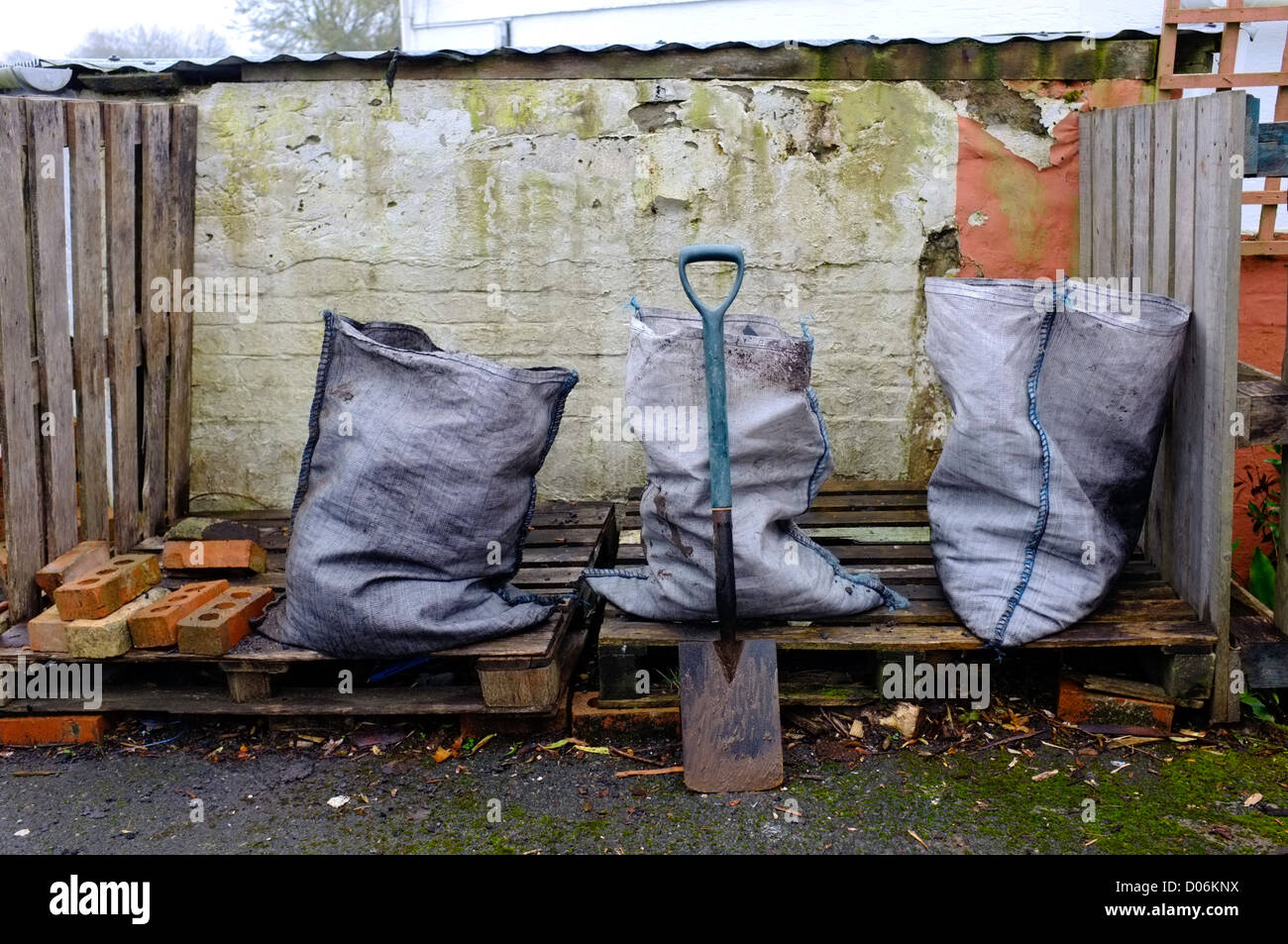 Three sacks of coal just delivered onto wooden pallets outside a house in Cornwall, UK Stock Photo