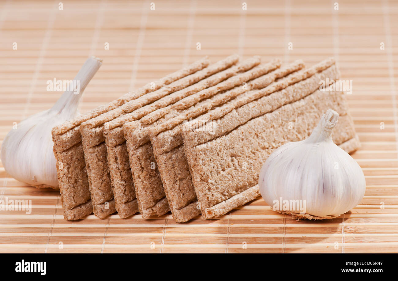 dry crisp bread slices with garlic bulbs Stock Photo