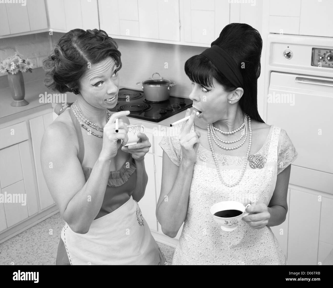 Gossping women smoking and drinking tea in a retro-style kitchen Stock Photo