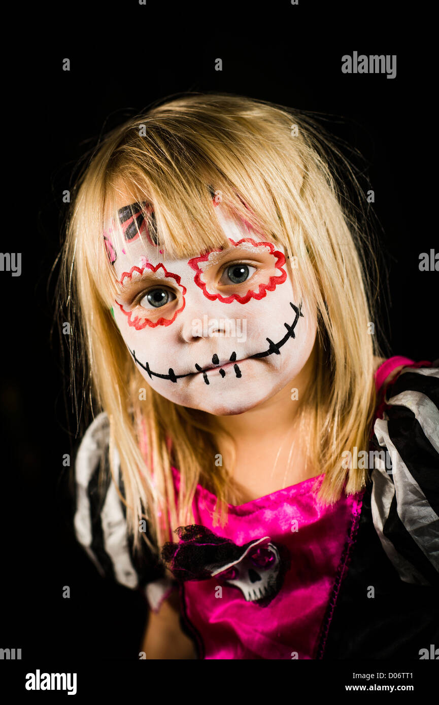 A young girl with face painted in Halloween theme style horror UK Stock Photo