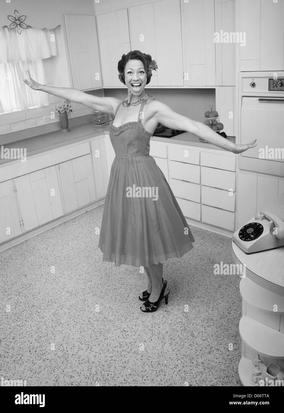 Happy Caucasian woman in a retro styled kitchen scene Stock Photo