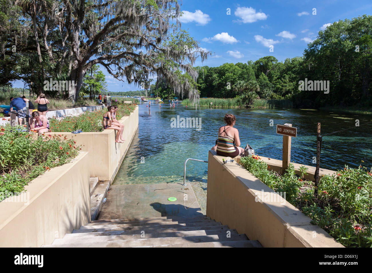 Women and teen girls sit on wall at Salt Springs Recreation Area in the Ocala National Forest, Florida Stock Photo