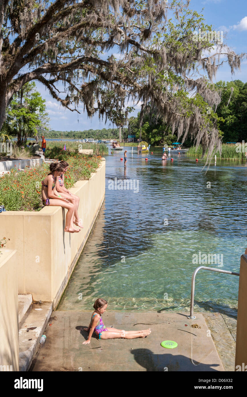 Teen girls sit on wall at Salt Springs Recreation Area in the Ocala National Forest, Florida Stock Photo