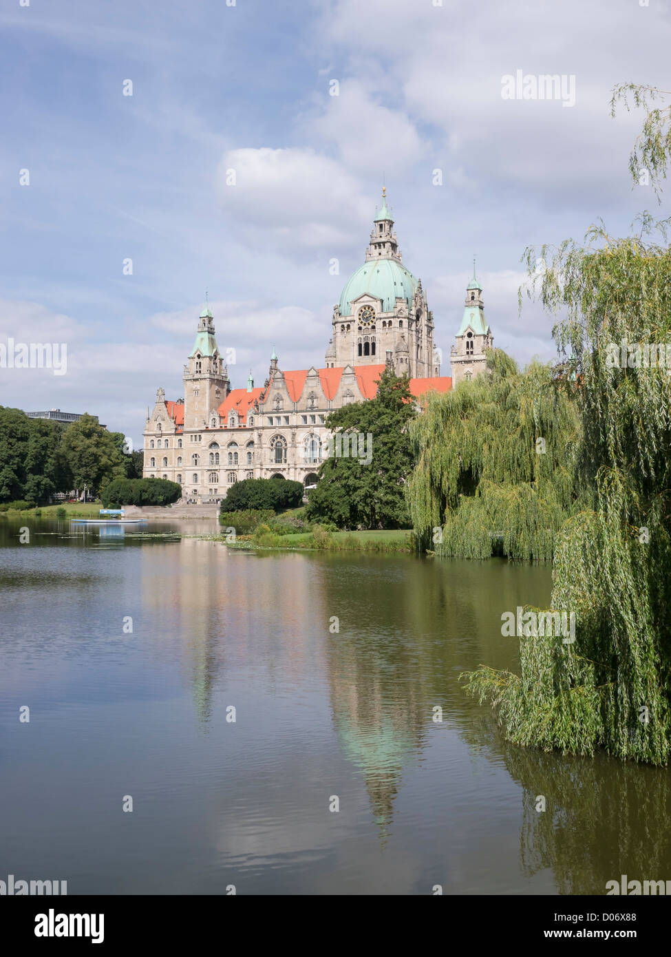 The Neues Rathaus (new city hall) in Hannover, Germany. It is set in a public park with trees and a large lake. Stock Photo