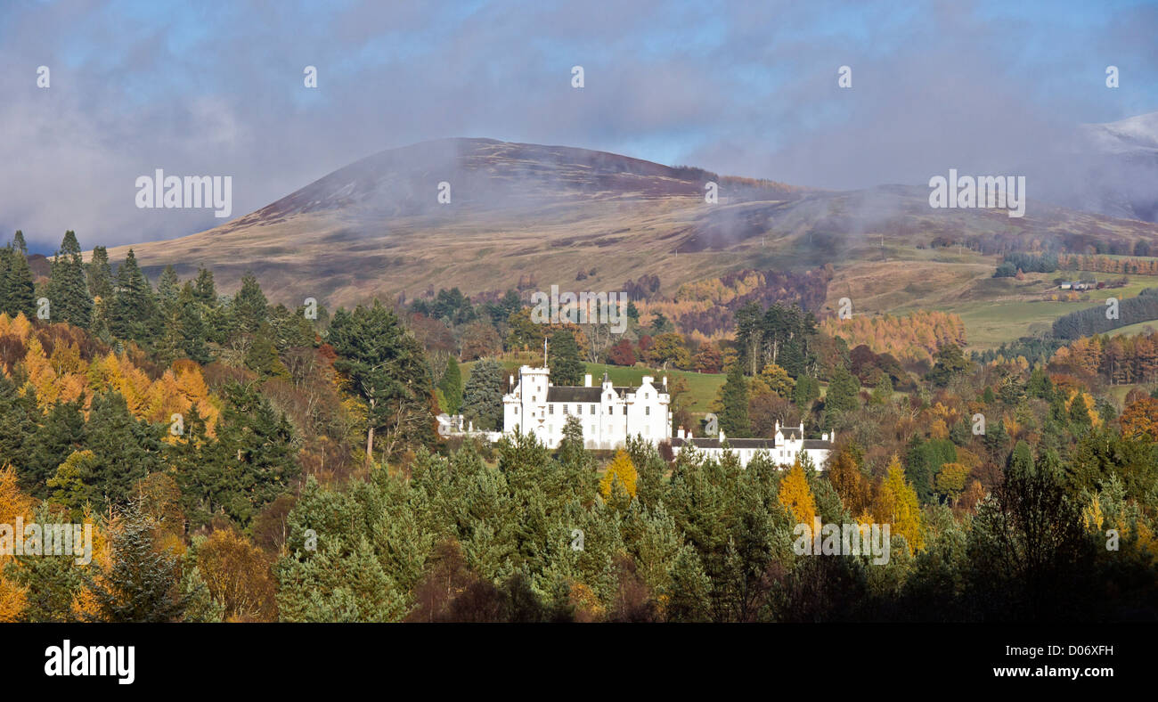 Clouds lifting over Blair Castle with mountain behind in Blair Atholl Perthshire Scotland on a sunny autumn day as seen from the A9 road Stock Photo