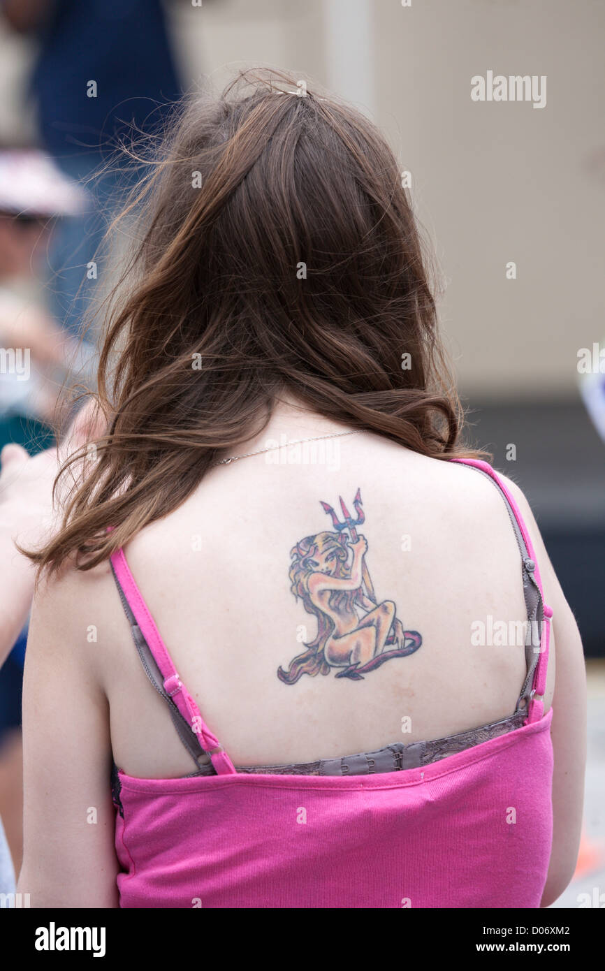 She Devil tattoo on back of young fair skinned woman Stock Photo