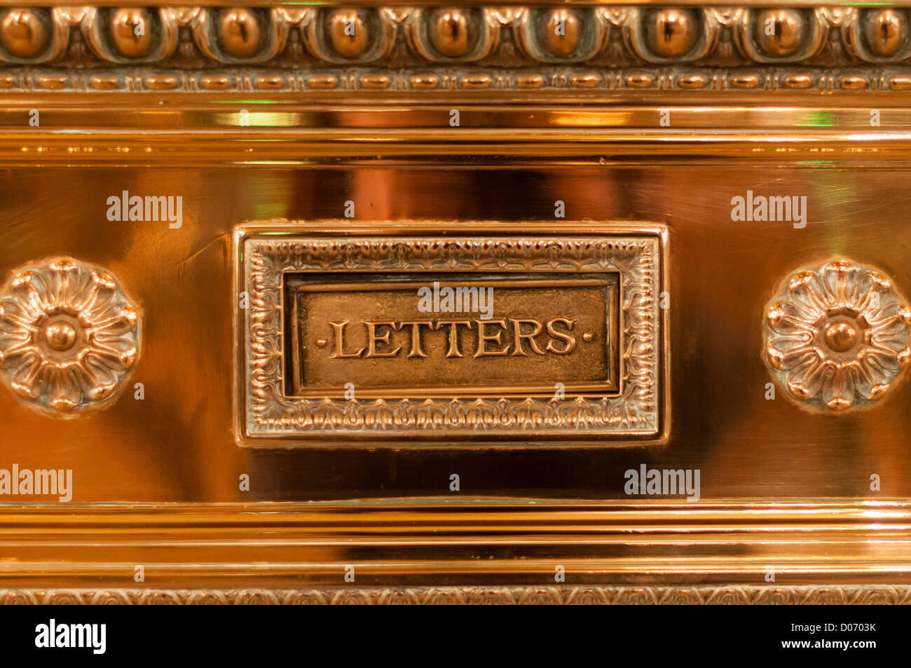 Close-up of old fashioned, decorative, brass letter slot for mail. Stock Photo