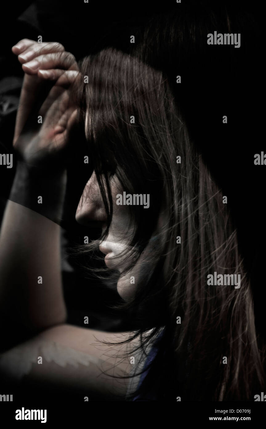 A Young Woman appearing unhappy ,depressed in a creative digital art image in the format of a composite toned monochrome montage Stock Photo