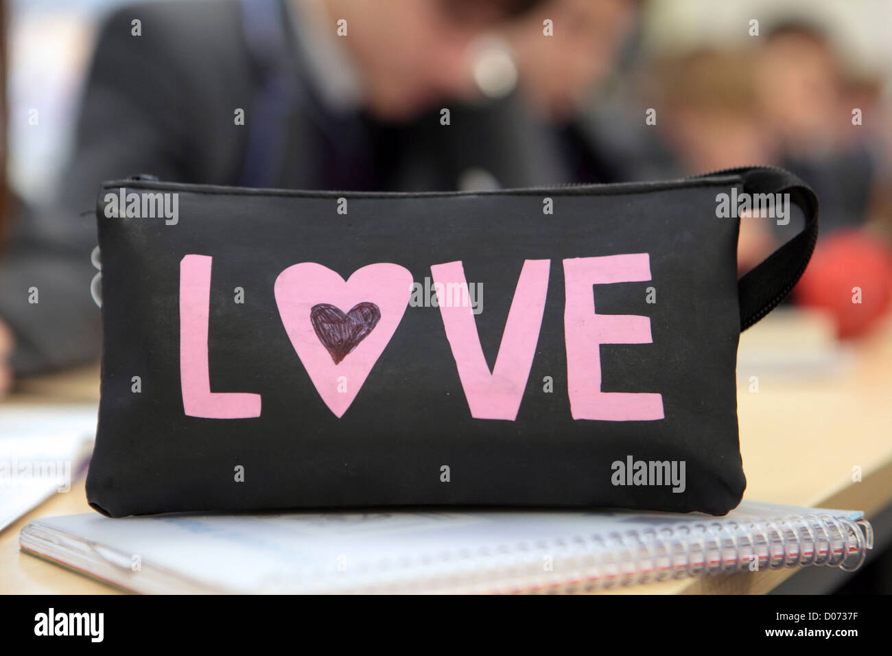 Pencil case on school desk, table out of focus children behind, Secondary School, UK Stock Photo