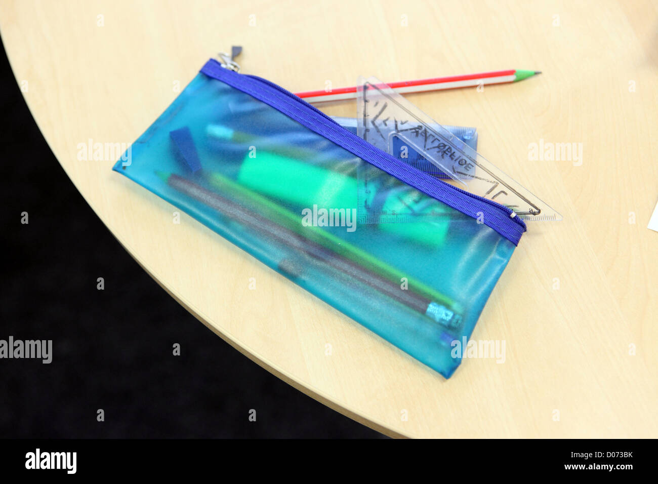 Transparent blue plastic school pencil case on tabletop with pencils and set square, studio photograph Stock Photo
