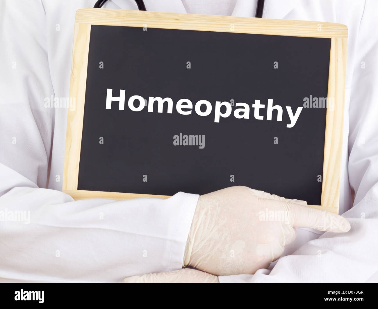 Doctor shows information on blackboard: homeopathy Stock Photo