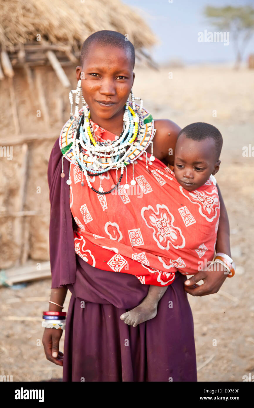Maasai Mother with two babies at Tanzania;East Africa;Africa;Authentic Cultural Village in Olpopongi;Maasai Men Worrier Stock Photo