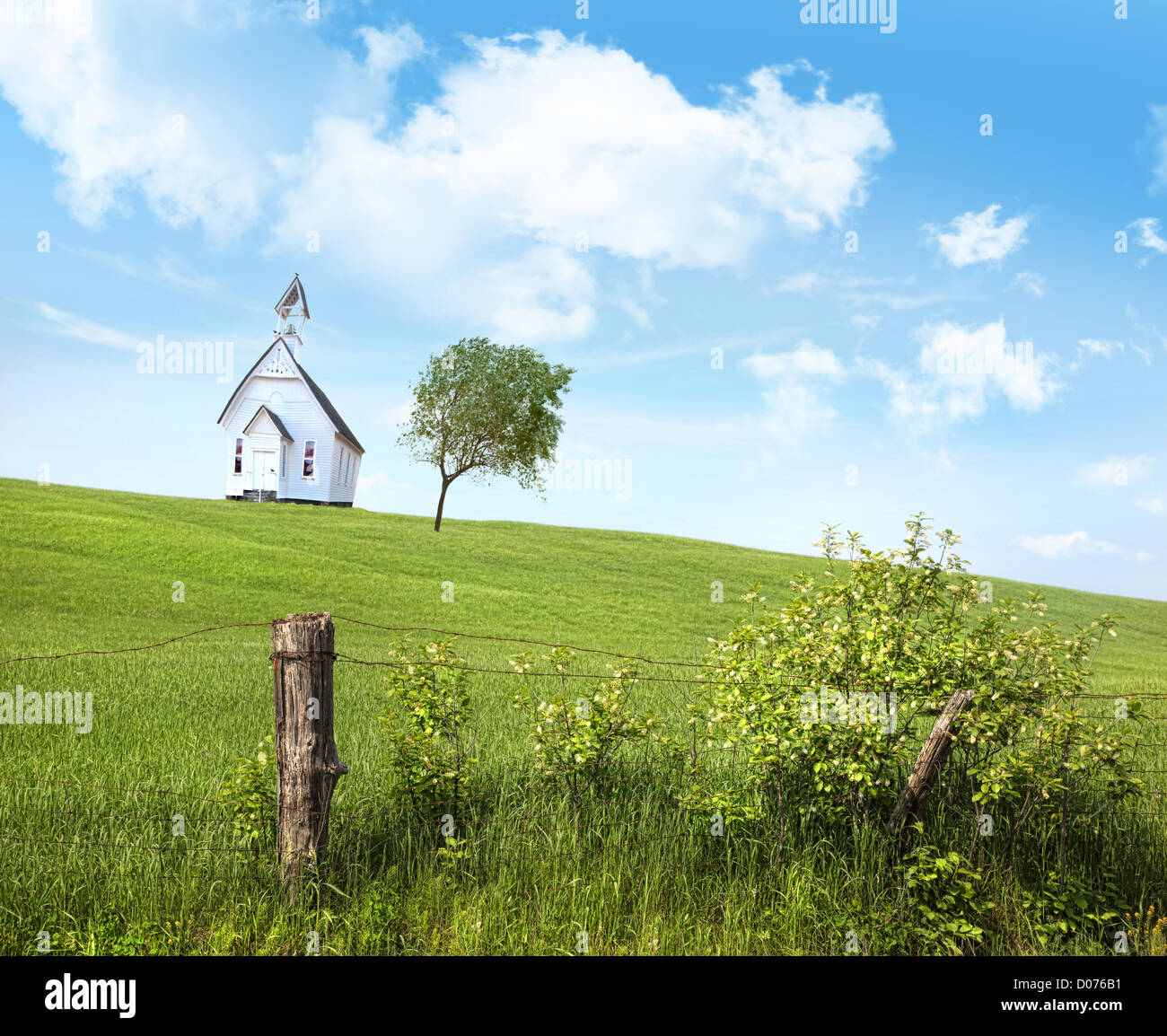 Old country school house on a hill against a blue sky Stock Photo