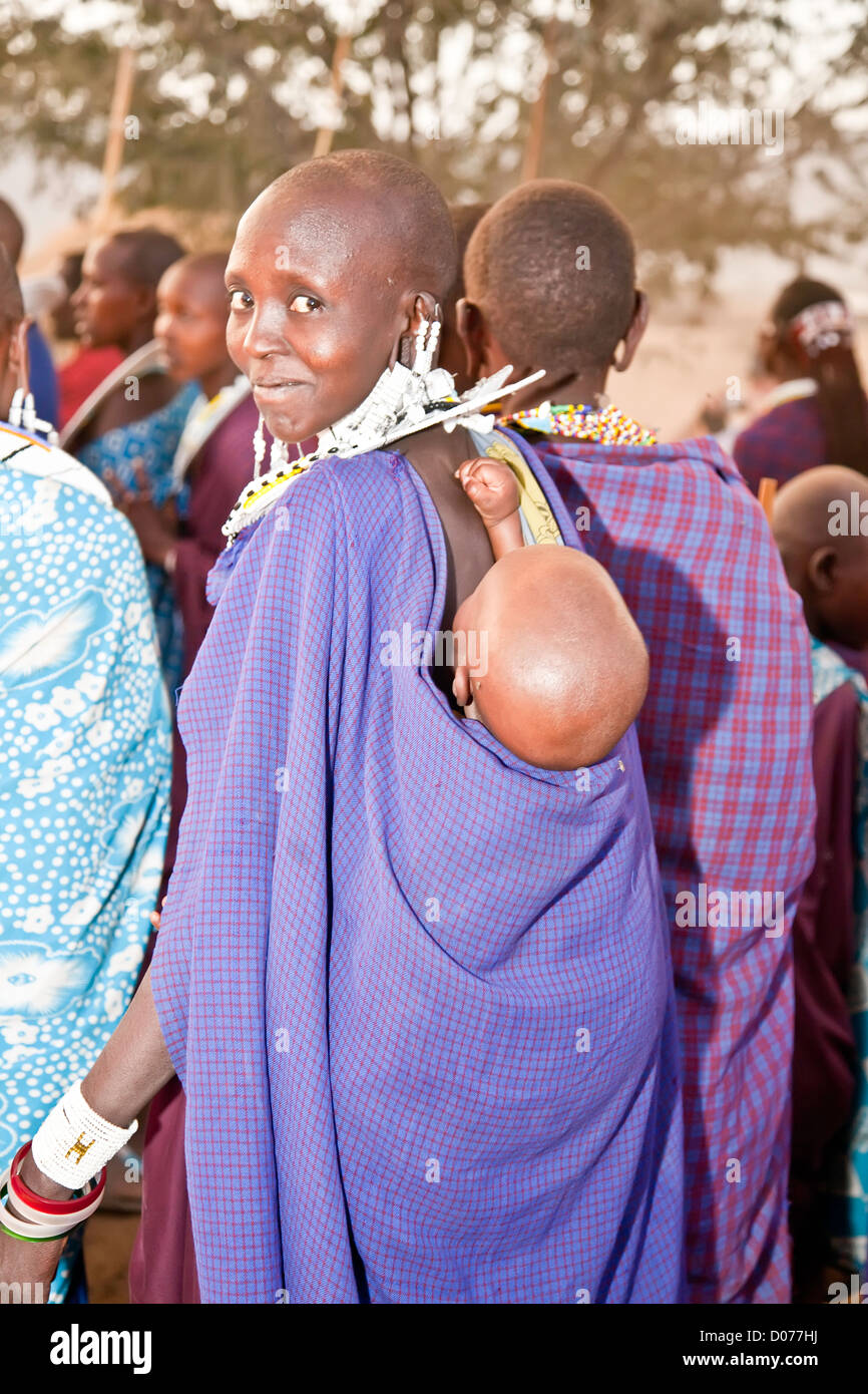 Maasai mother with baby on her back at Tanzania;East Africa;Africa;Authentic Cultural Village in Olpopongi;Maasai Stock Photo