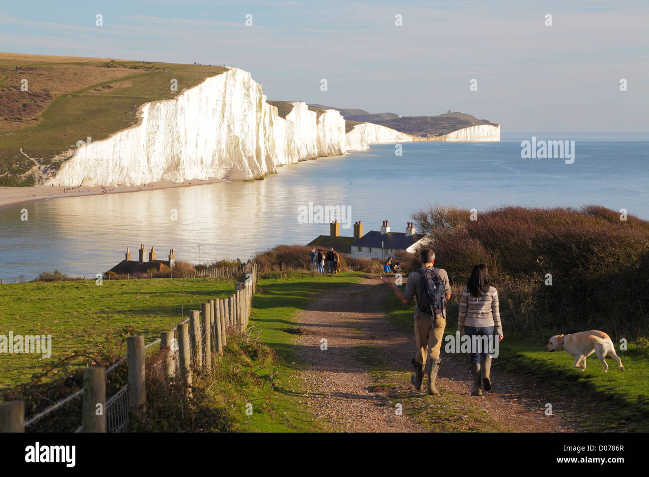 Seven Sisters cliffs and coastline viewed from Seaford Head East Sussex England UK GB with couple walking dog on South Downs Way National Country Park Stock Photo