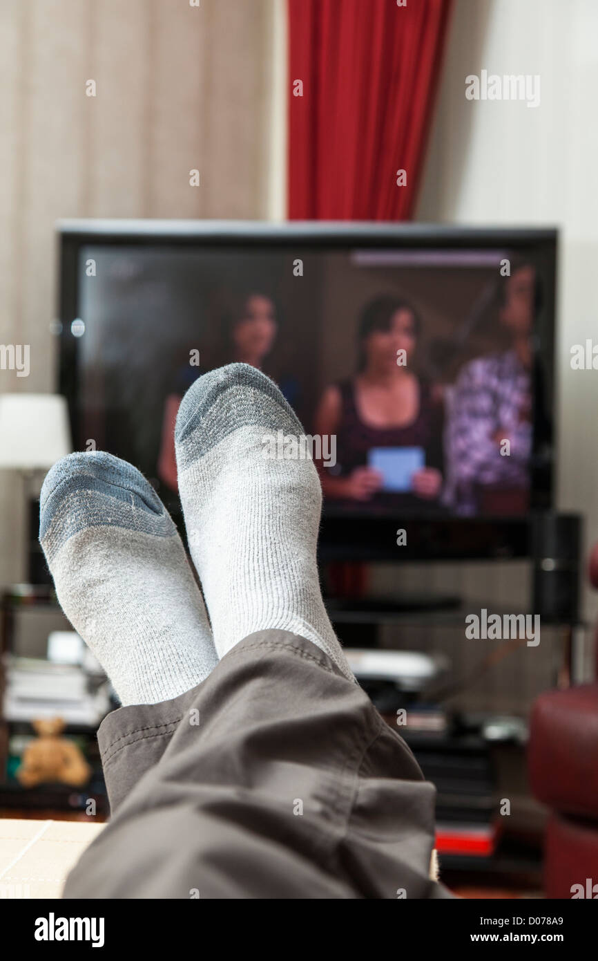 Male Relaxing And Watching Television While Wearing Socks Feet Are In Front Of Television Stock 