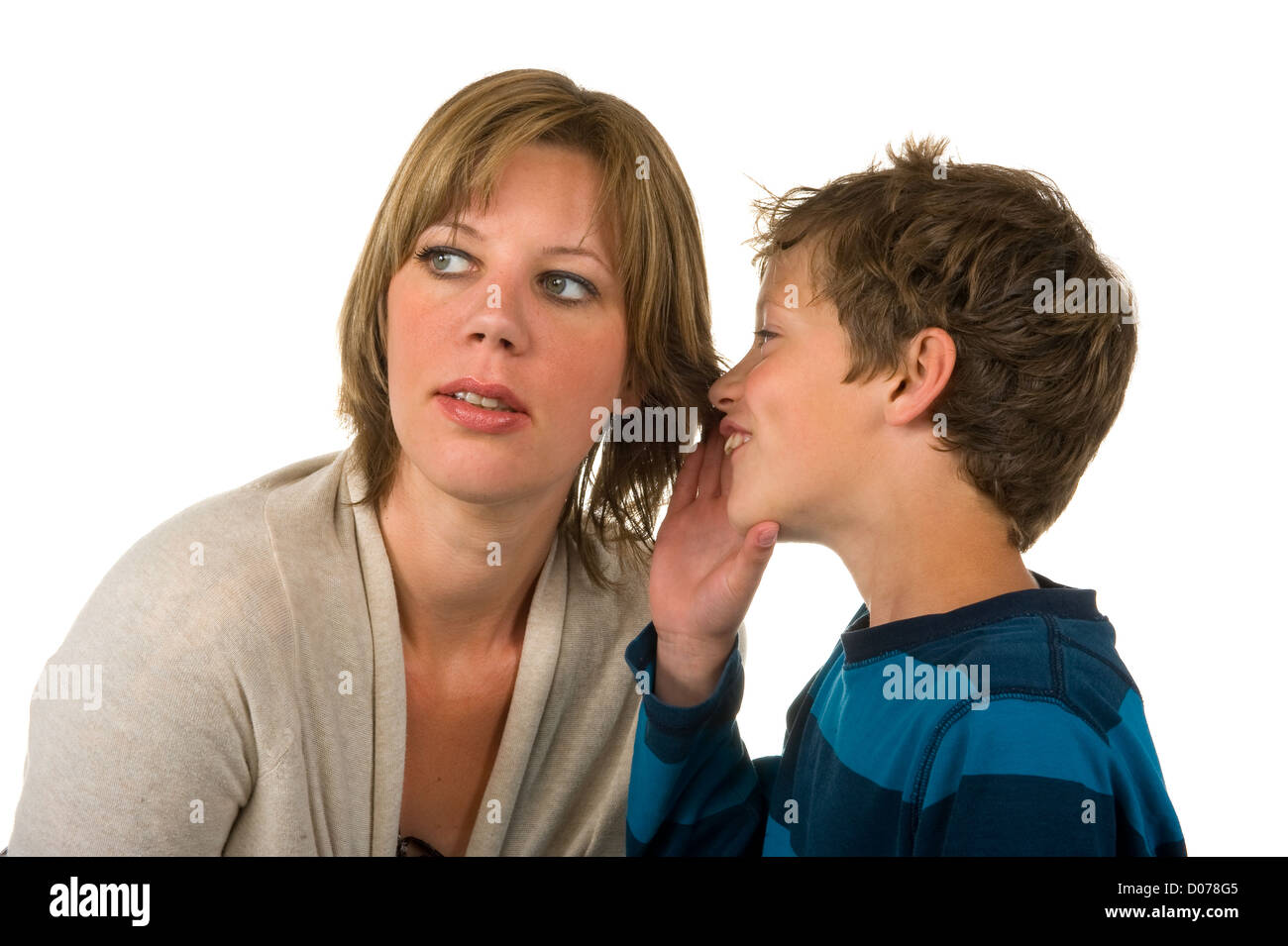 A young boy is whispering a secret in his mothers ear Stock Photo