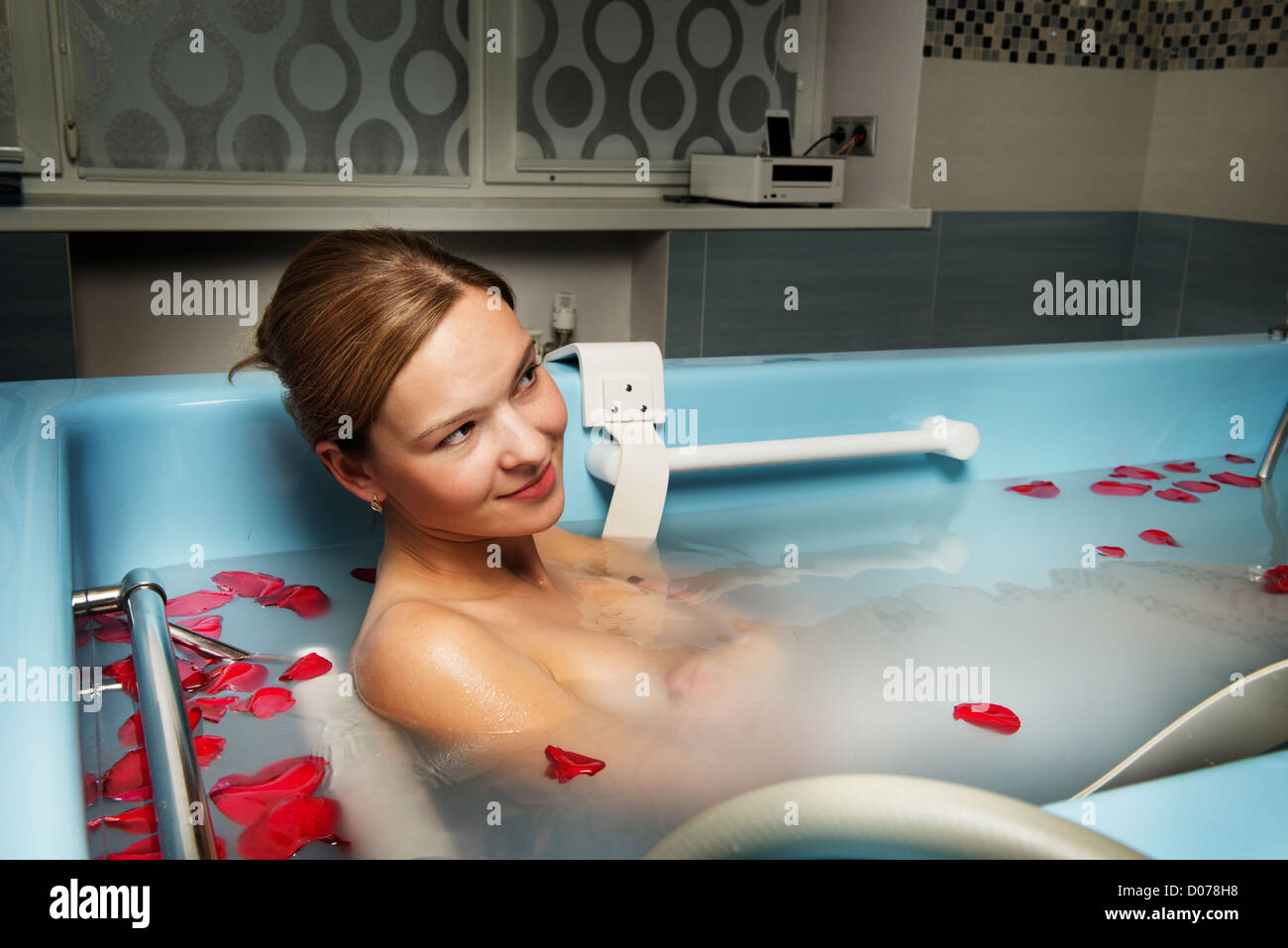 nude woman bath petals flower relaxation spa salon one young Stock Photo