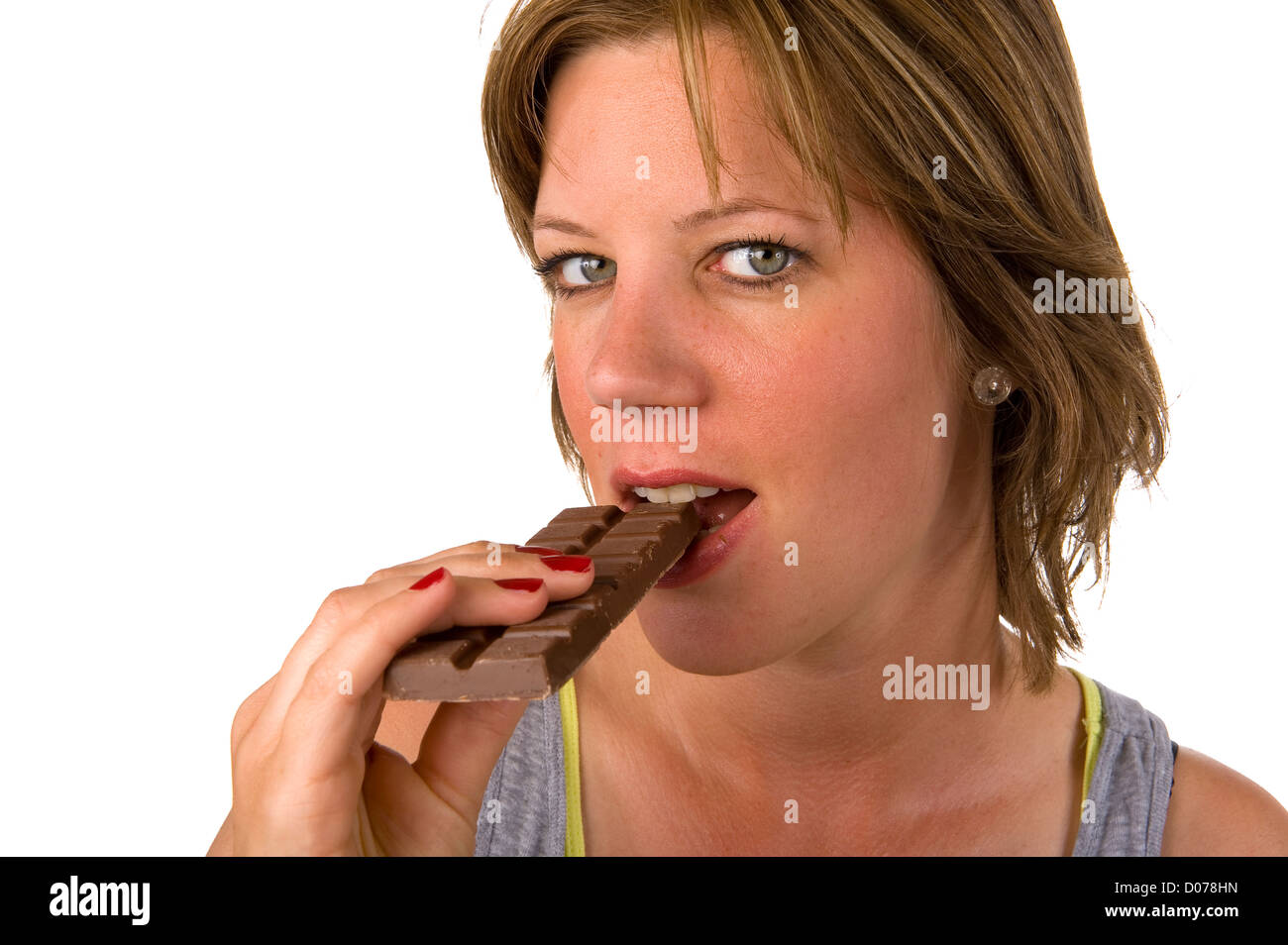 A young woman eating a piece of chocolate Stock Photo