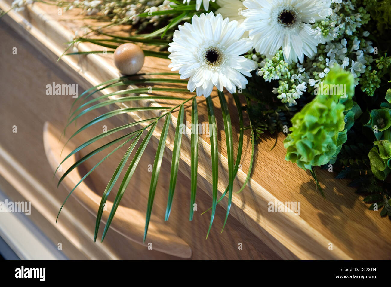 A coffin with a flower arrangement at a mortuary Stock Photo