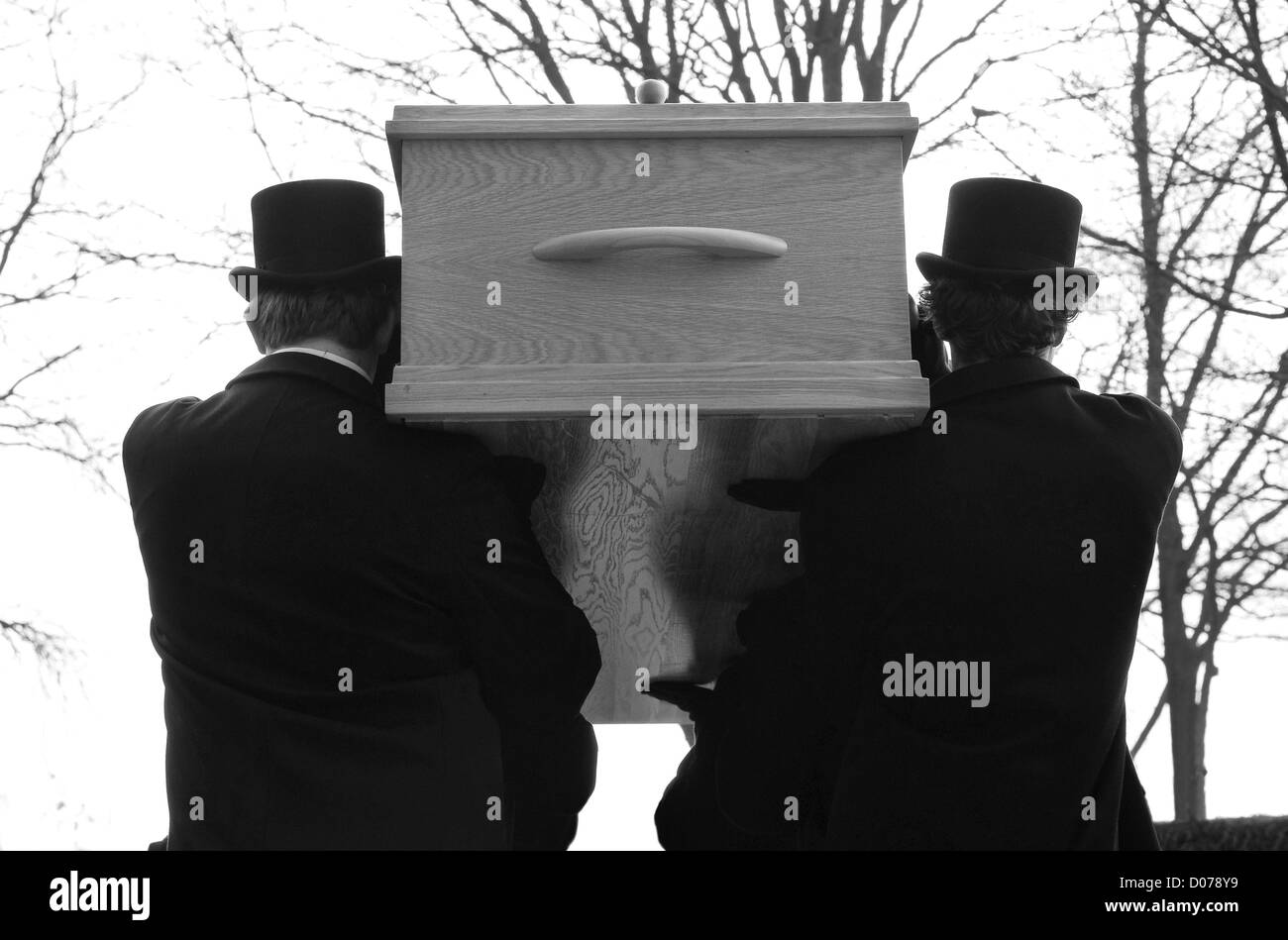 Bearers are carrying a coffin to a cemetery Stock Photo