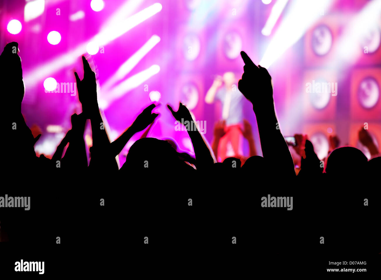 People with hands up having fun on a music concert / disco party. Stock Photo