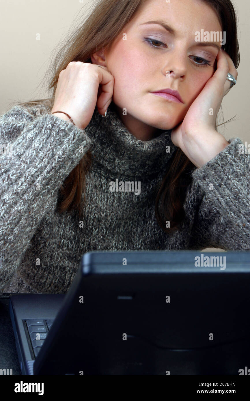 2000s Early period of computer technology: Young woman looking at laptop screen . Stock Photo