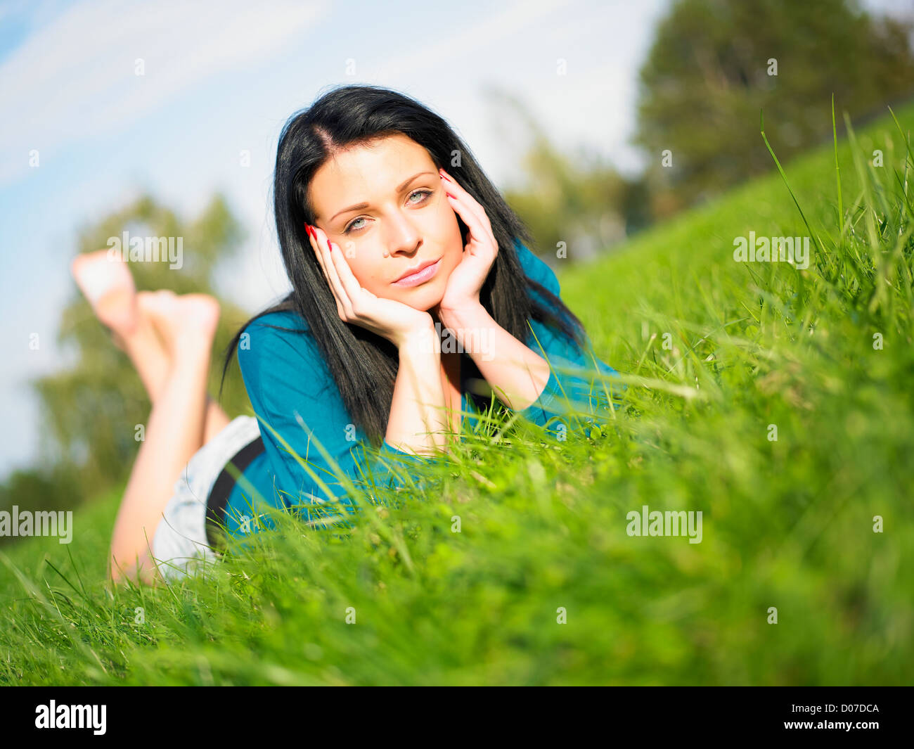 Young woman relaxing in park on green grass Stock Photo - Alamy