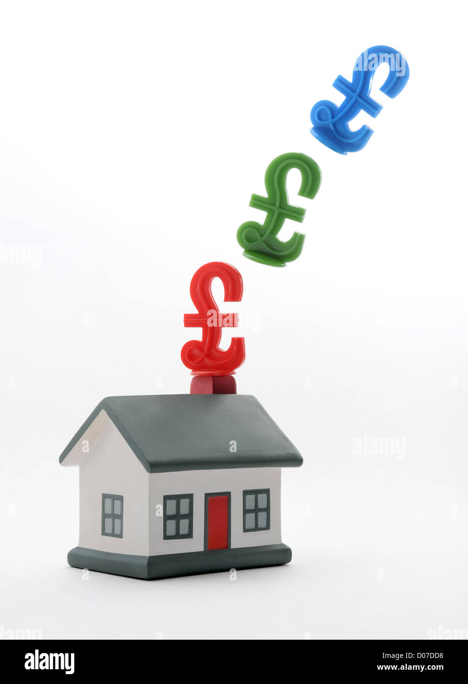 HOUSE WITH BRITISH POUND SIGNS FROM CHIMNEY RE HOUSE PRICES HOUSING PROPERTY MARKET MORTGAGES ENERGY COSTS SELLERS VALUES UK Stock Photo