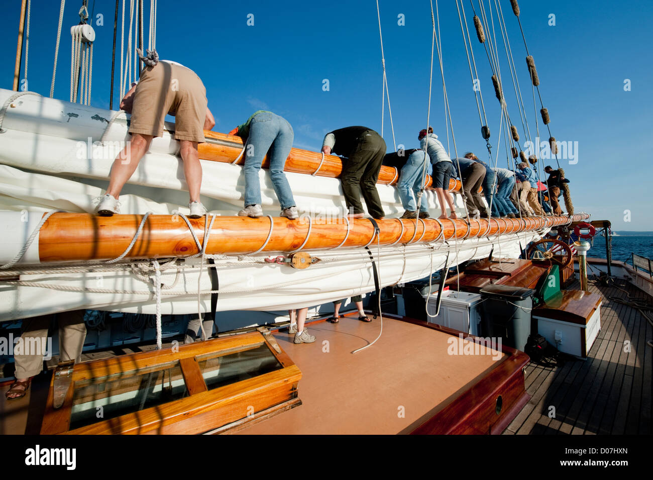 Crew members aboard the historic schooner 'Zodiac' put away the sails after a sailboat race in Port Townsend, Washington, USA. Stock Photo