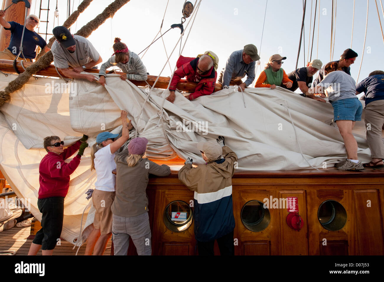 Crew members aboard the historic schooner 'Zodiac' put away the sails after a sailboat race in Port Townsend, Washington, USA. Stock Photo
