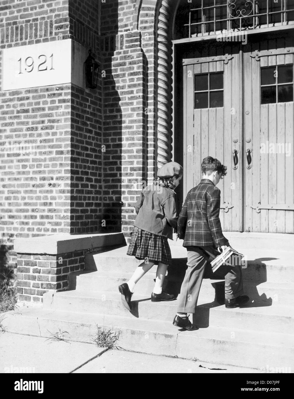 Two children walking into school Stock Photo