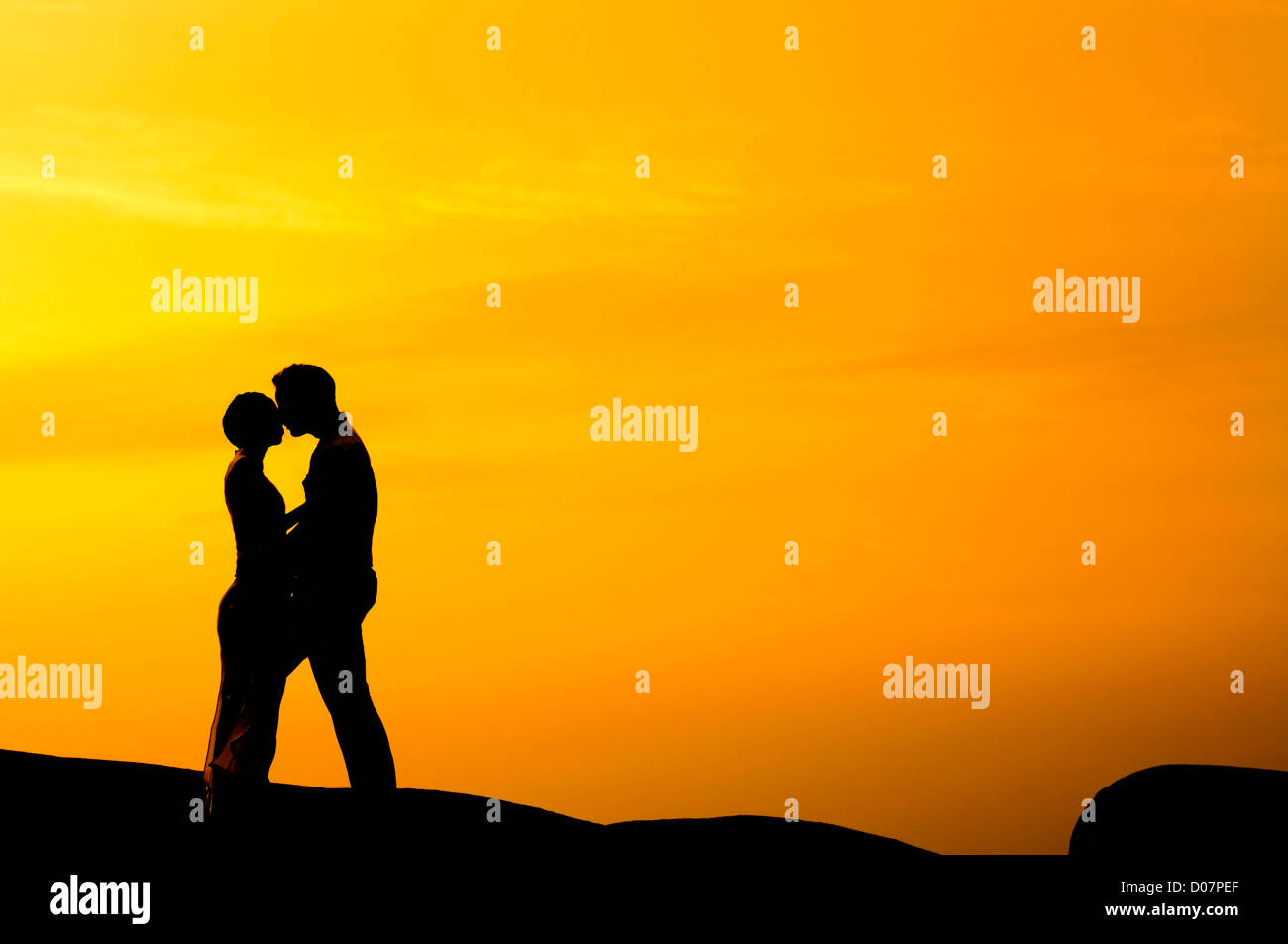 Silhouette of couple kissing in sunset Stock Photo - Alamy