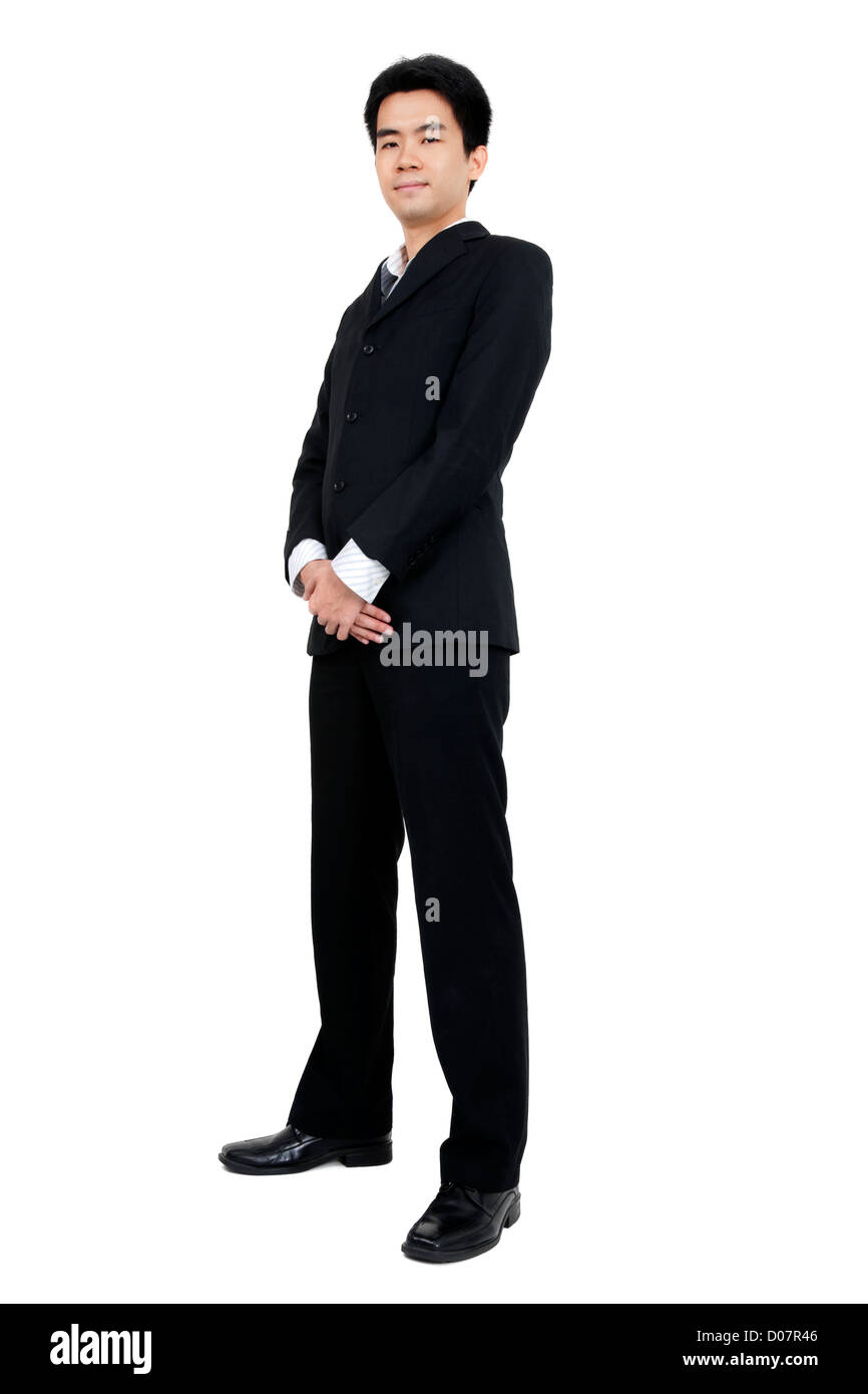 Full length of a smiling young Asian executive standing against isolated white background Stock Photo