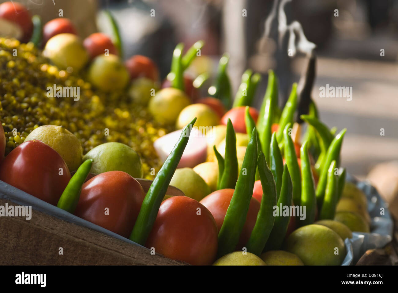 Close-up of tomatoes with chilli and lemon at a snack stall, Delhi, India Stock Photo
