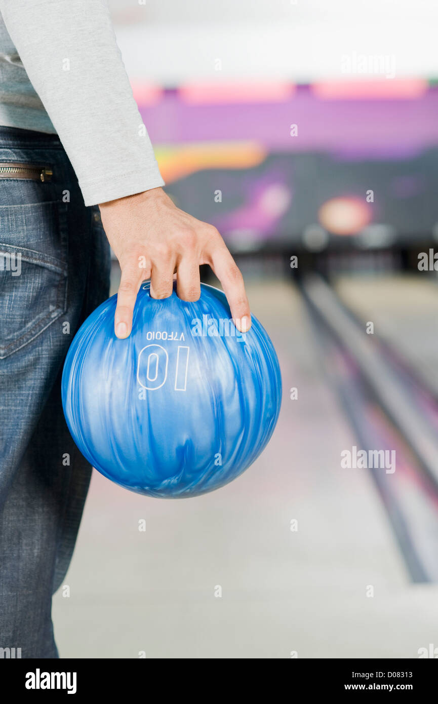 Young man holding a bowling ball in a bowling alley Stock Photo