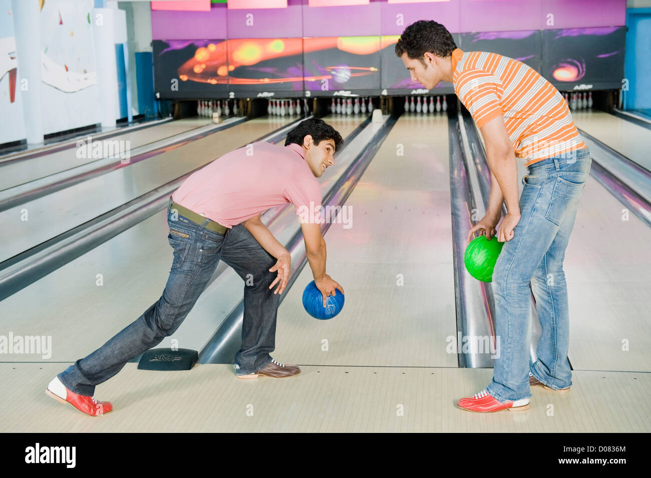 Two young men bowling in a bowling alley Stock Photo Alamy