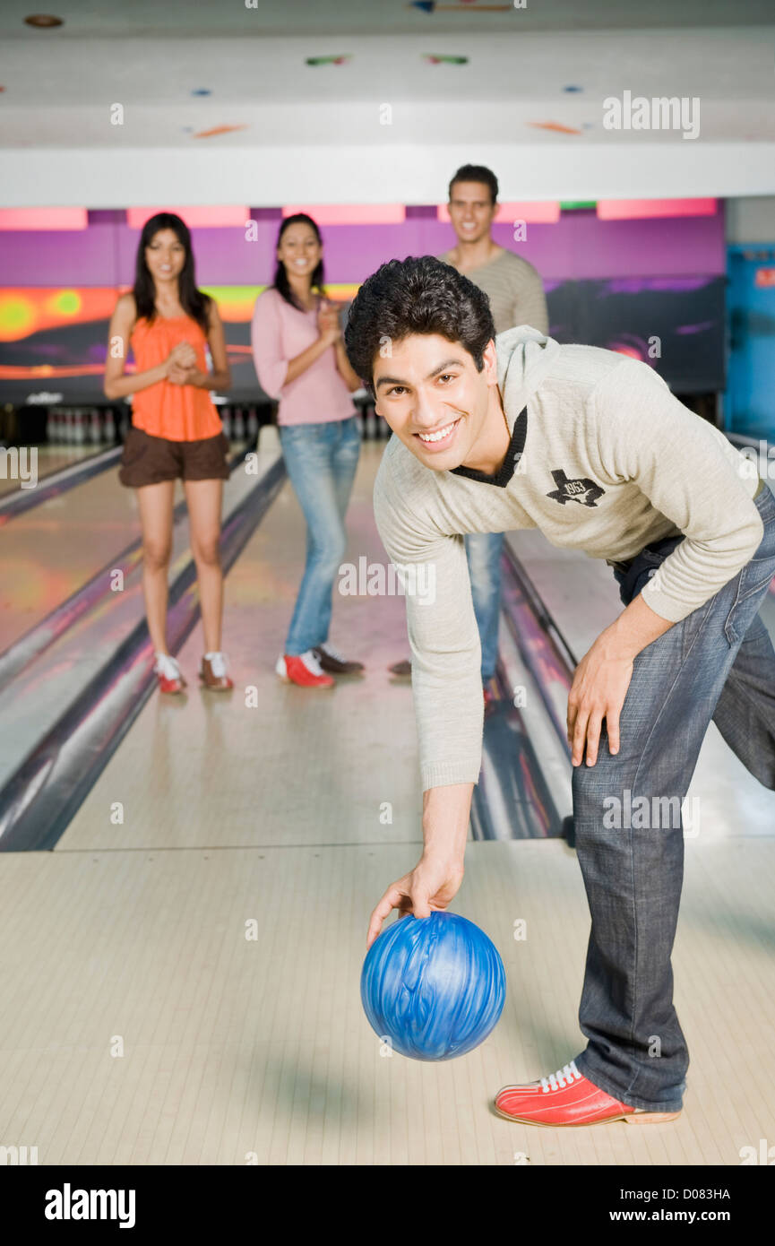 Young man bowling in a bowling alley with his friends in the background  Stock Photo - Alamy