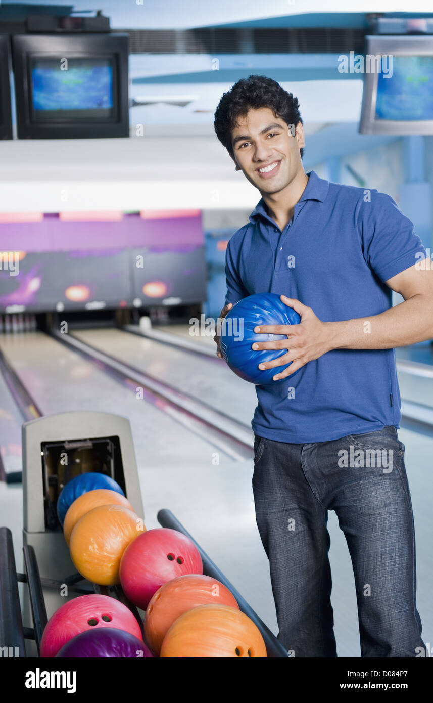 Young man holding a bowling ball in a bowling alley Stock Photo Alamy