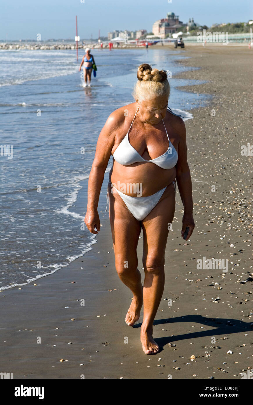 Androgynous mature senior man woman genderfluid person healthy fit body wearing white bikini Venice Lido beach Italy 2000s. 2009 HOMER SYKES Stock Photo