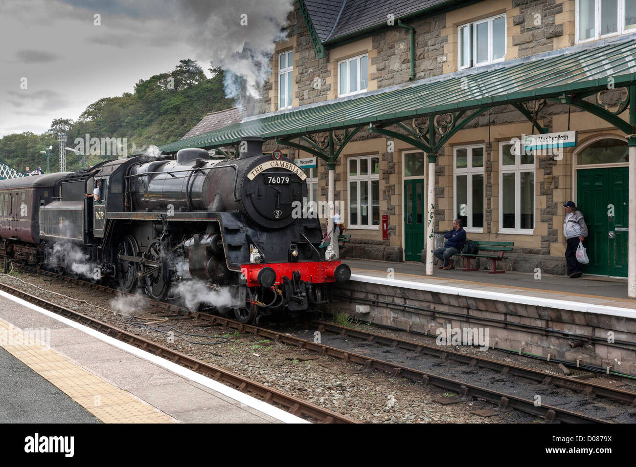 Steam train the Cambrian is pulling passenger coaches into Machynlleth  railway station for its trip along the coast to Pwllheli Stock Photo