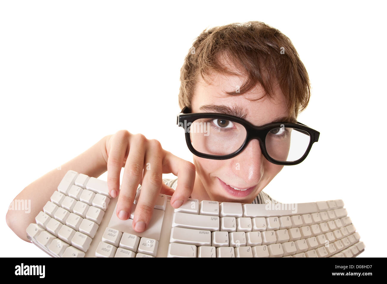 Teen smiles behind a computer keyboard over white background Stock ...