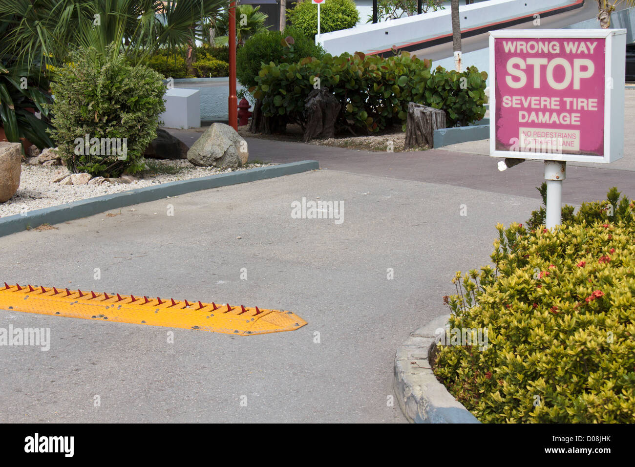 Hotel parking lot exit with traffic spikes and warning sign stop