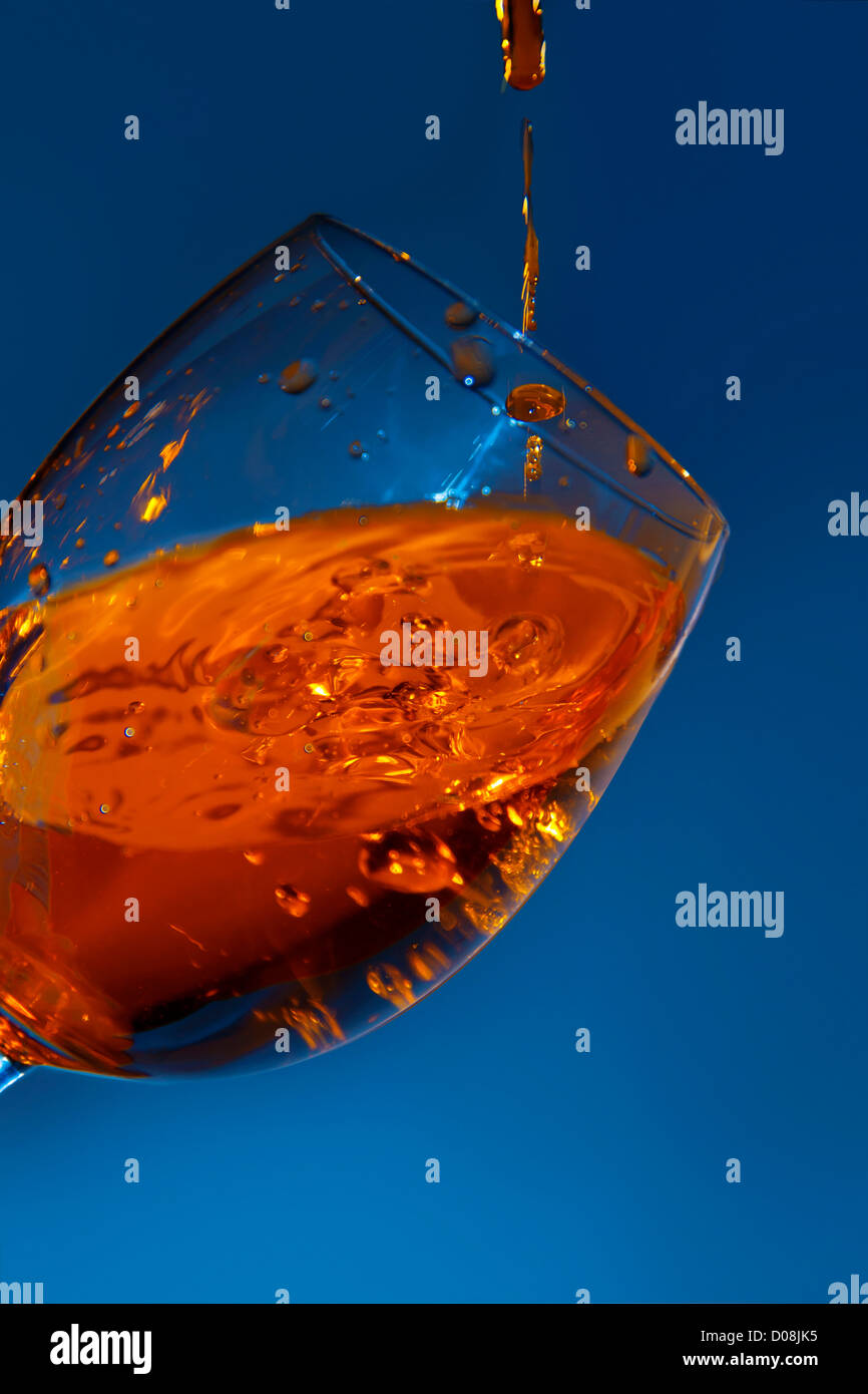 Glass with being poured water, on a dark blue background Stock Photo