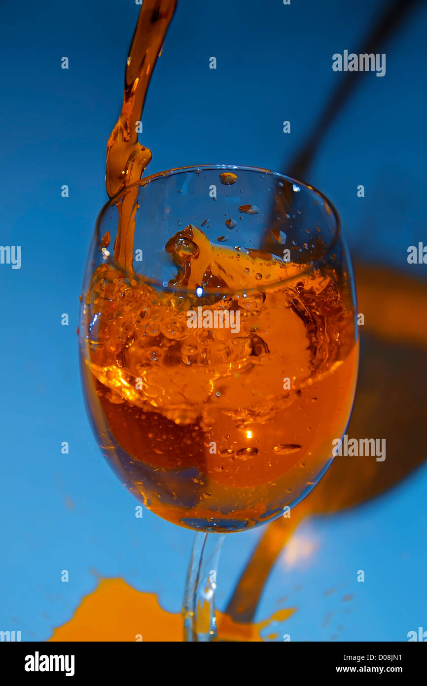 Glass with being poured water with top, on a dark blue background Stock Photo